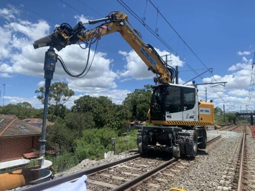 excavator auger drilling holes for railway